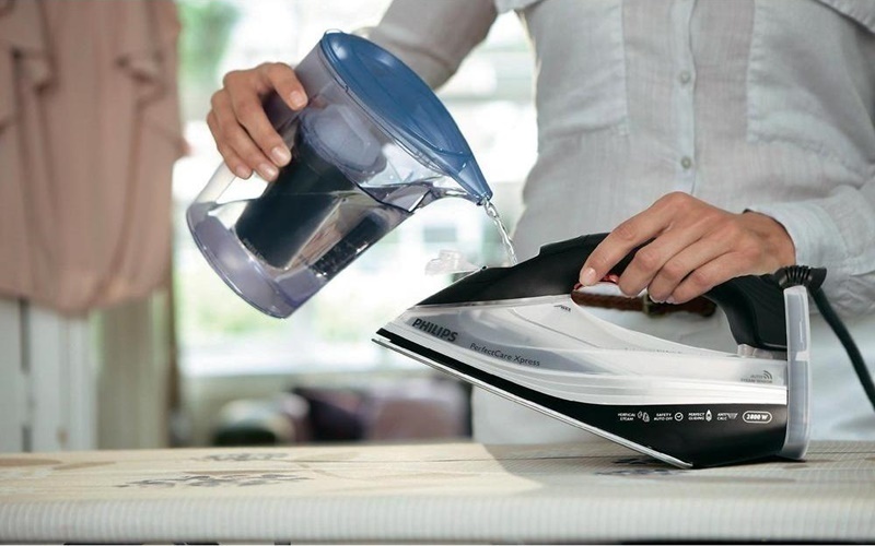 Châm nước vào bình bàn ủi mỗi khi hết nước