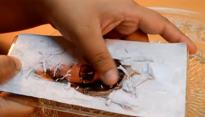 Dùng tay cạo hết lớp giấy trên ốp lưng điện thoại