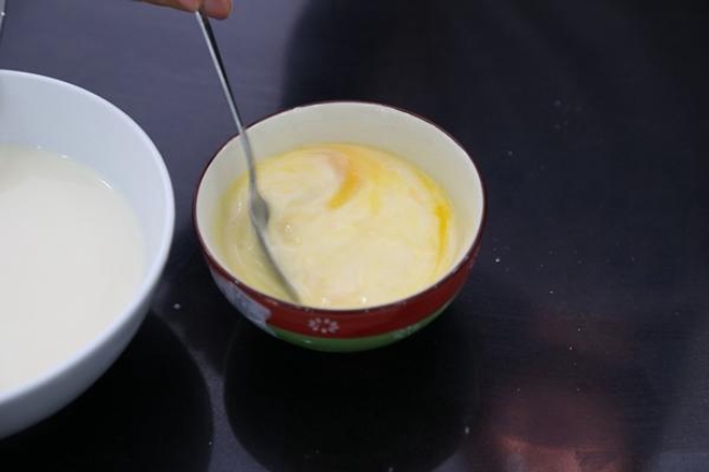 Cho từ từ sữa đã nấu vào hỗn hợp trứng, khuấy nhẹ theo một chiều để hỗn hợp hòa tan. 